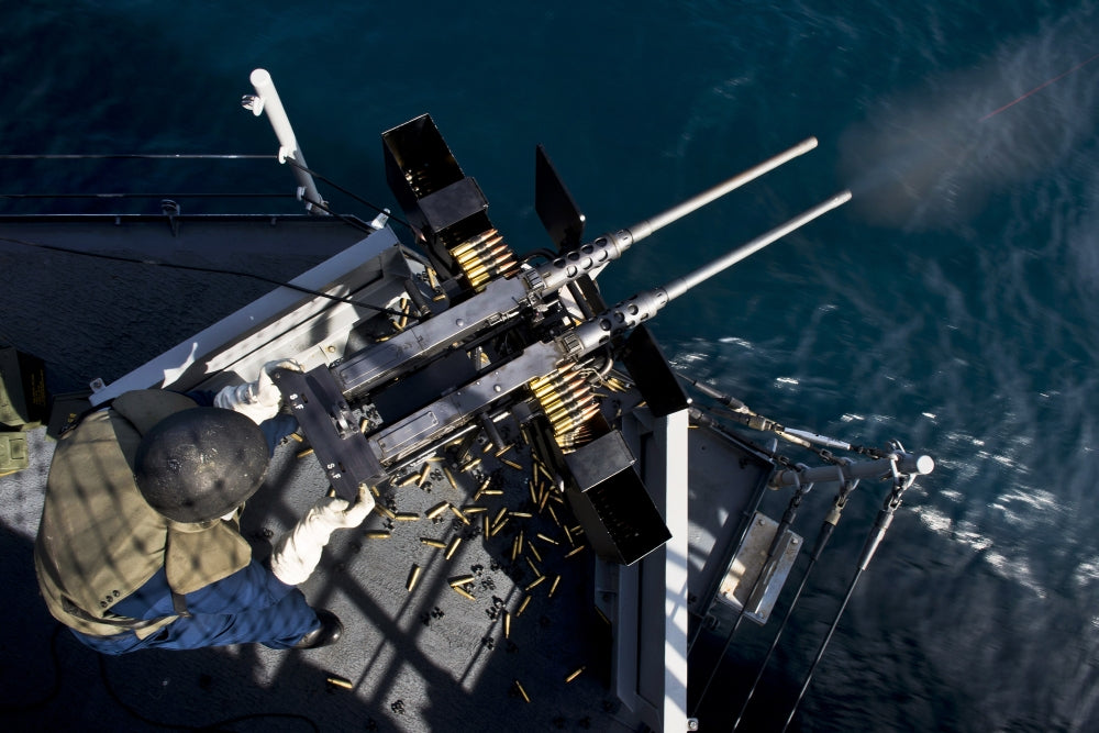 Seaman firing twin .50 caliber machine guns during a live-fire exercise aboard USS Boxer, Pacific Ocean.