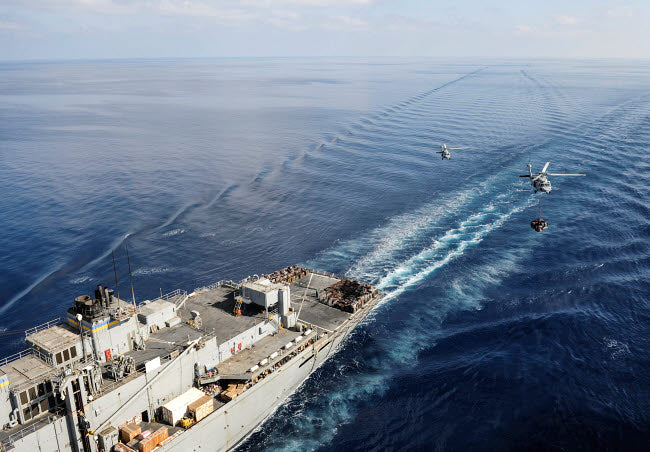 MH-60S Sea Hawk helicopters transporting supplies to ships poster print.