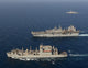 USNS Robert E Peary conducting a vertical replenishment with USS Bataan poster print