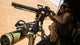 A Crew Chief Mounts a M134 Minigun Poster Print showcasing military aviation.