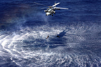 MH-60S Seahawk lowers a rescue swimmer into the water poster print