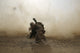 U.S. Marine shielding from dust as CH-53E Super Stallion helicopter lifts off in Afghanistan