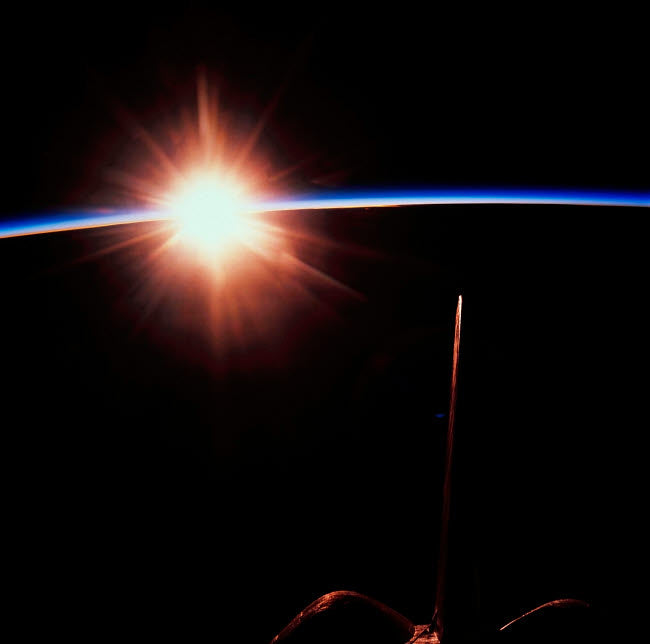 Sunrise as viewed in space poster print showcasing Earth and vibrant colors.