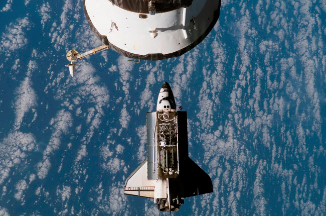 Space Shuttle Atlantis approaching the International Space Station poster print.
