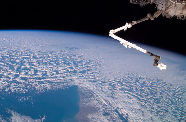 Robotic Canadarm2 Above Earth Poster Print by Stocktrek Images
