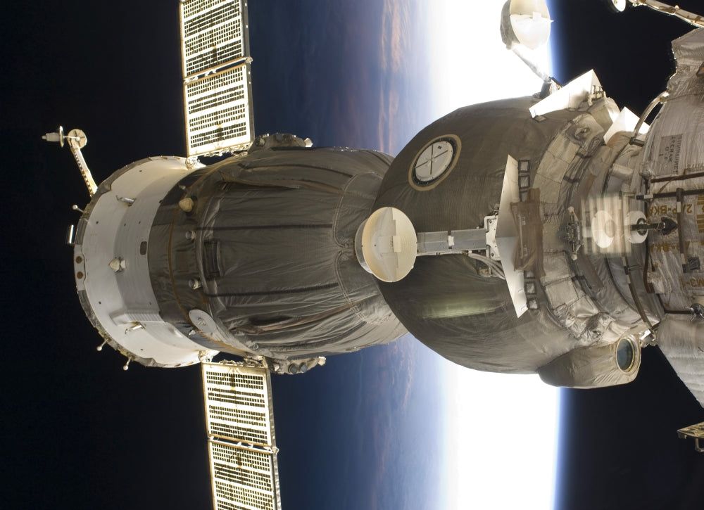 Soyuz spacecraft poster print with Earth backdrop.