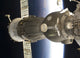 Soyuz spacecraft poster print with Earth backdrop.