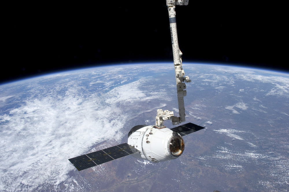 SpaceX Dragon cargo craft grappled by Canadarm2 at International Space Station poster print