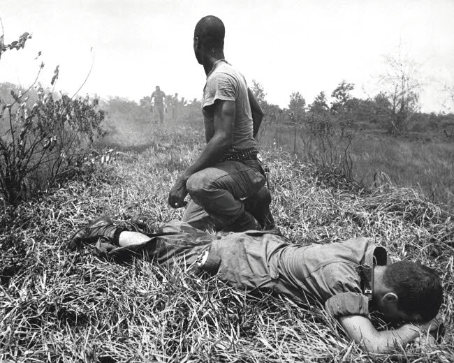 Poster print of a young American lieutenant treated by a medic in Vietnam, 1966.