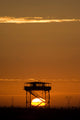 Guard Tower at Sunset Poster Print by Terry Moore showcasing a vibrant sunset sky.