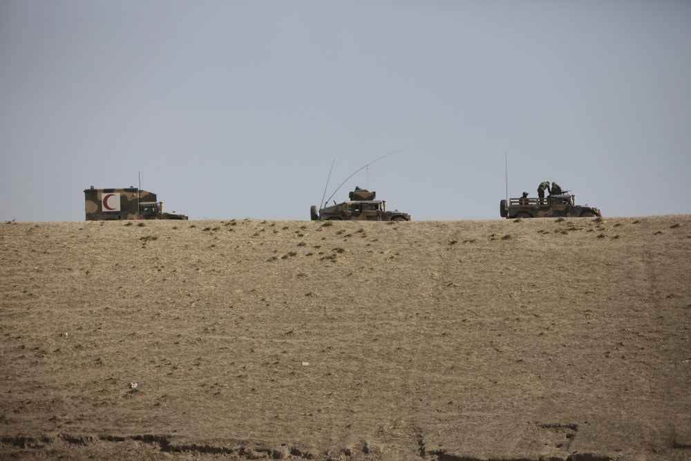Afghan Army HMMWV and ambulance navigating wadi ridge in Kunduz, Afghanistan poster print.