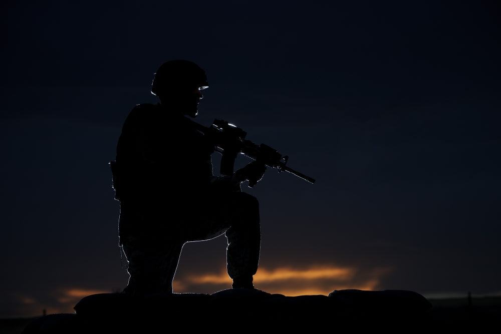 Partially silhouetted U.S. Marine on a bunker in Northern Afghanistan poster print.
