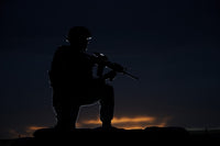 Partially silhouetted U.S. Marine on a bunker in Northern Afghanistan poster print.