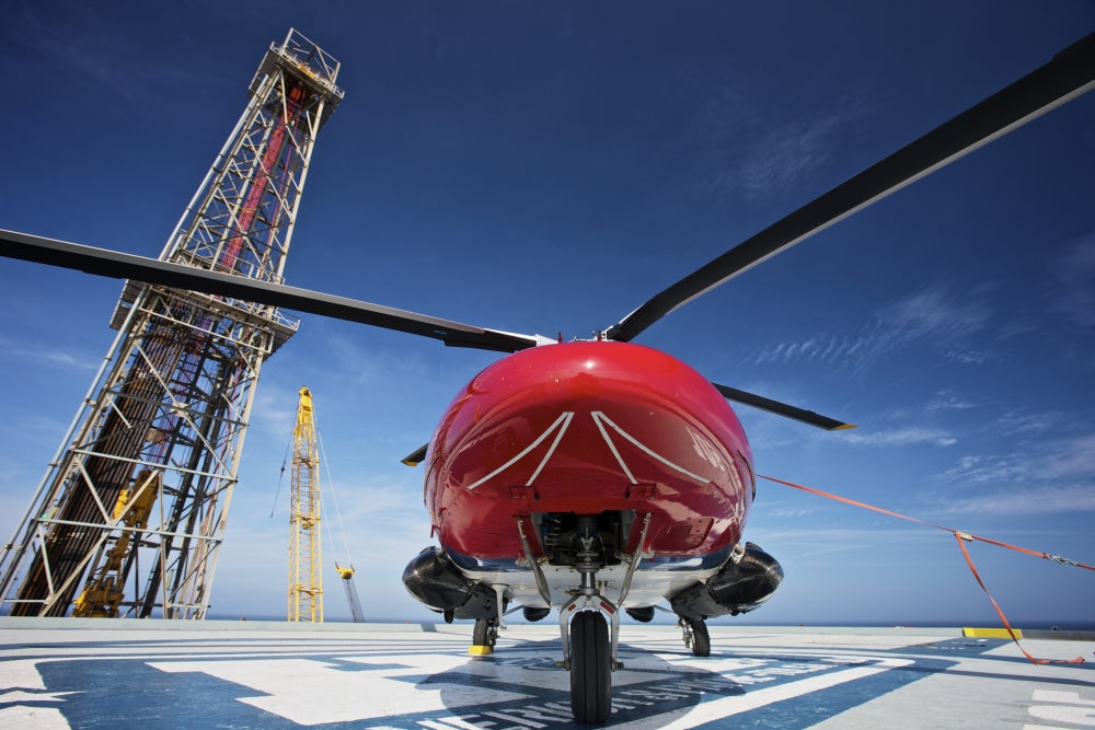 AgustaWestland AW109E helicopter parked on oil rig helipad in Gulf of Mexico.