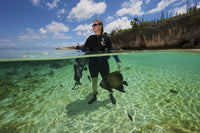 Diver looking out to sea with a French Angelfish swimming around in Bonaire, Caribbean.
