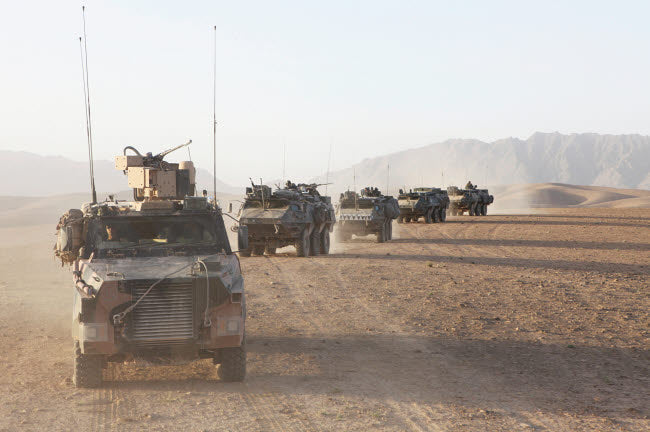 Convoy of Dutch Army vehicles in Afghanistan poster print showcasing military vehicles in action.