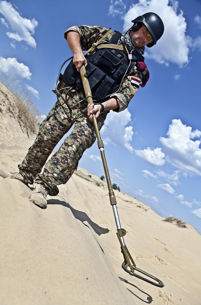Poster print of an Iraqi soldier in the desert with a metal detector.