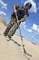 Poster print of an Iraqi soldier in the desert with a metal detector.