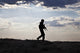 Silhouette of young soldier in military helmet against the sun poster print