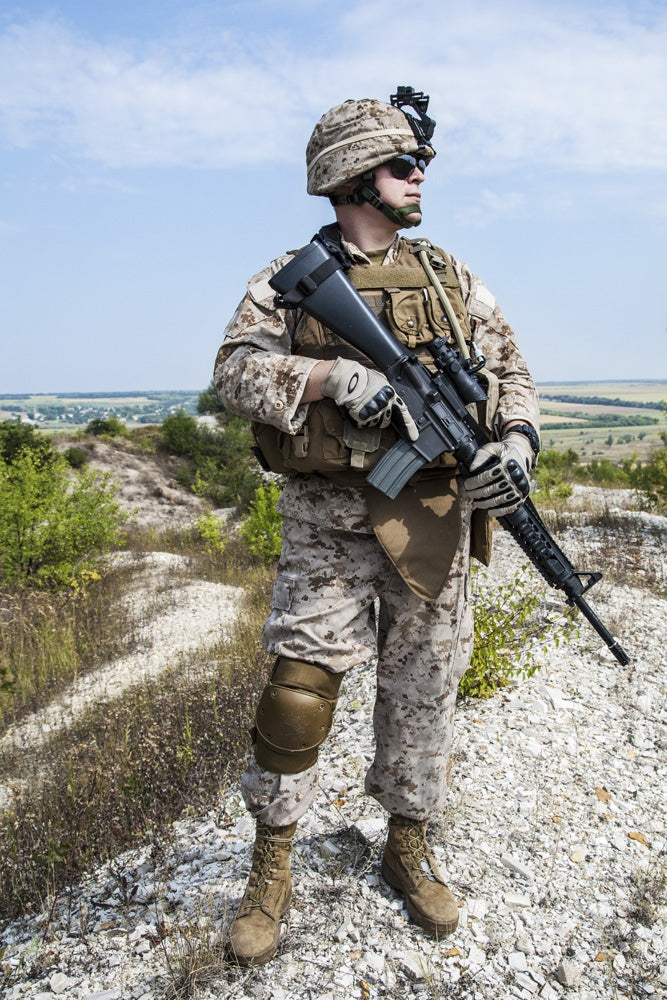 Close-up photo of U.S. Marine holding his rifle, by Oleg Zabielin.