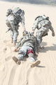 Poster print of airborne infantry paratroopers carrying injured soldier across desert sand by Oleg Zabielin