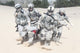 Airborne infantry paratroopers carrying injured soldier across desert sand poster print