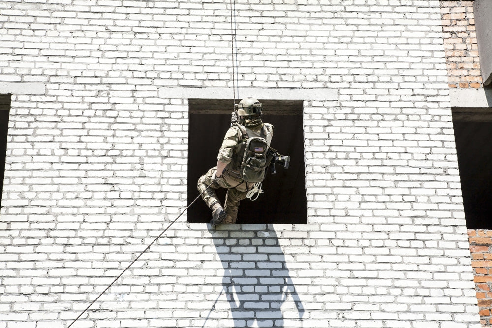 Soldier rappelling during assault exercises poster print by Oleg Zabielin