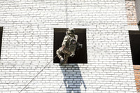 Soldier rappelling during assault exercises poster print by Oleg Zabielin