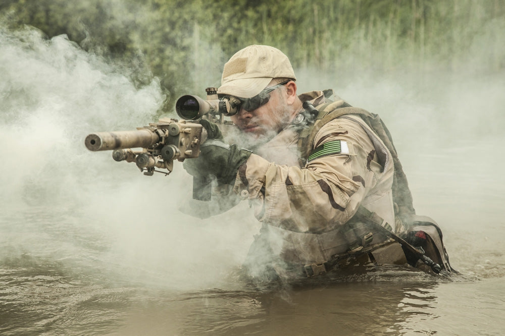 Navy SEAL team member crossing a river with weapons poster print.