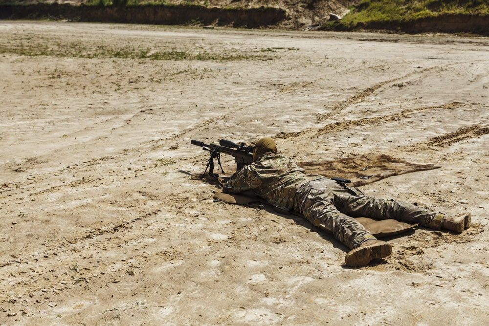 Young male sniper in camouflage with gun in the desert poster print.