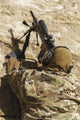 Young male sniper in camouflage with gun in the desert poster print