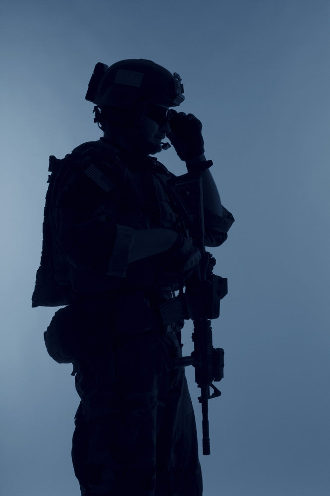 Silhouette of a U.S. Marine Corps Marsoc raider with weapon on blue background.