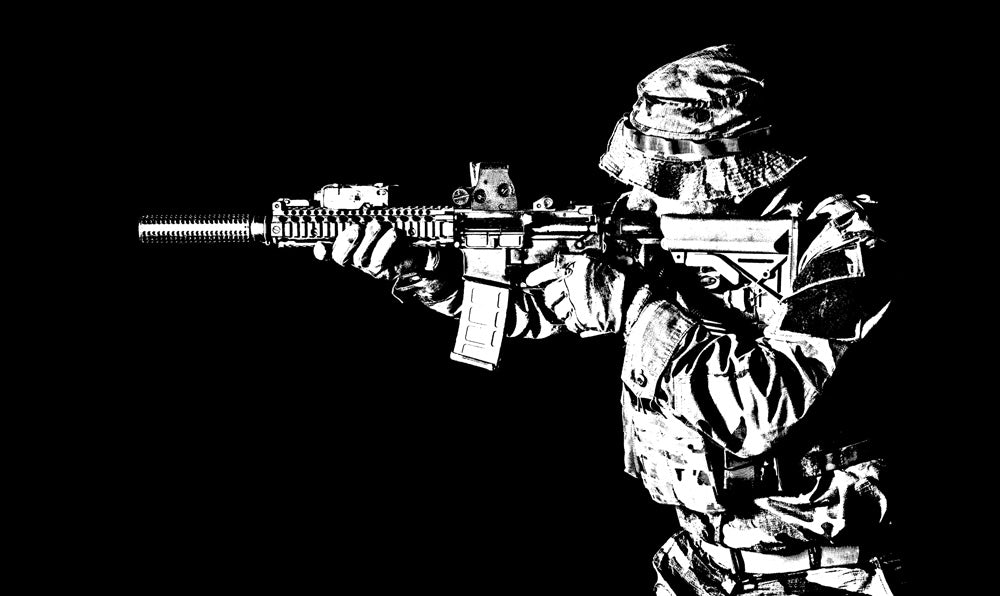 Backlit studio shot of a U.S. special forces soldier shooting his rifle poster print.