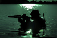 Silhouette of a special forces soldier crossing a river during a night raid in the jungle poster print.