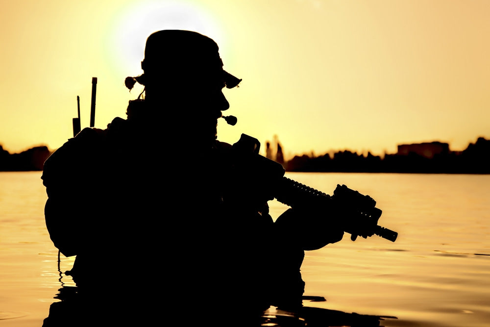 Silhouette of special forces soldier during river raid in jungle poster print