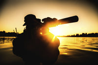 Silhouette of a special forces soldier during a river raid in the jungle poster print