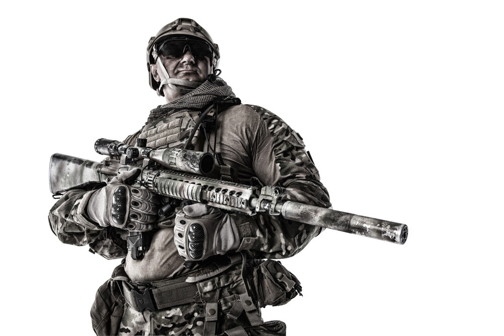 Half-length portrait of a muscular soldier in field uniform with sniper rifle.