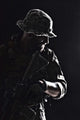Contour backlight portrait of a bearded special forces soldier in uniform with weapon.