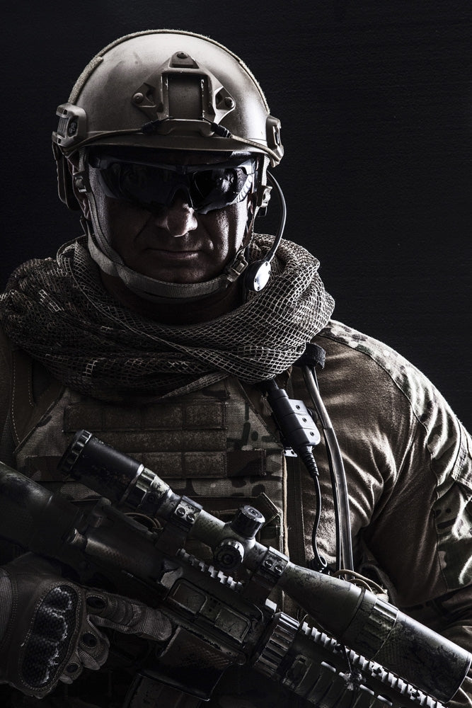 Contour backlight portrait of a special forces soldier in uniform with weapon.
