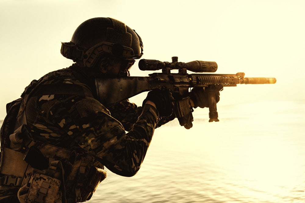 Silhouette of army soldier with rifle against an orange sunset poster print.