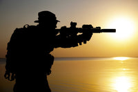 Silhouette of Army soldier against an orange sunset poster print.
