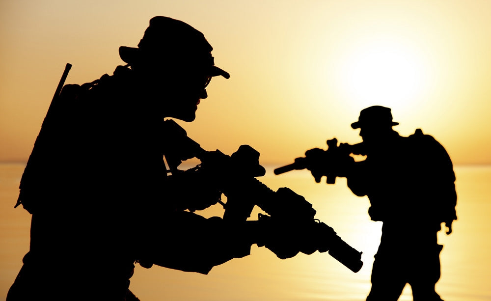 Silhouette of Army soldiers crossing a river at sunset poster print by Oleg Zabielin.