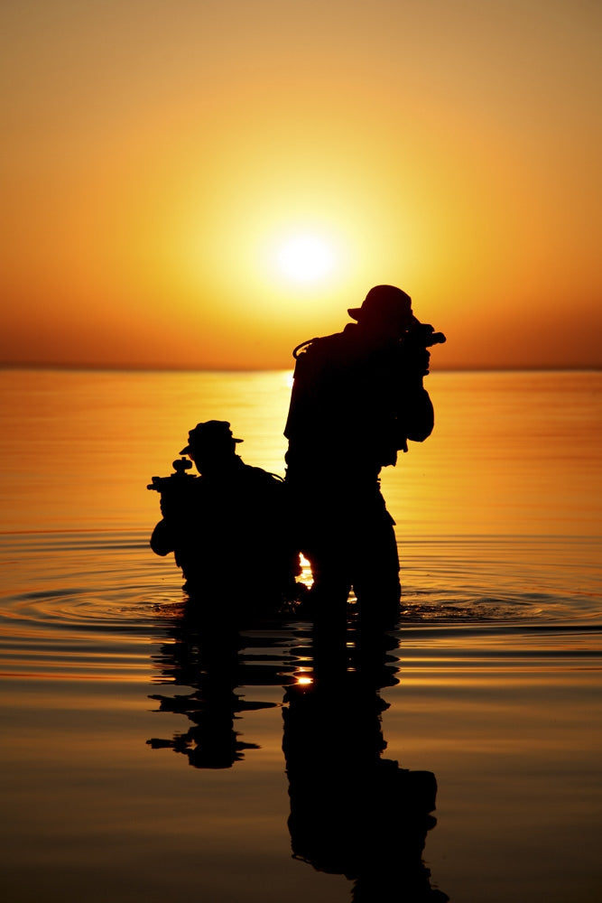 Silhouette of Army soldiers crossing a river against an orange sunset poster print by Oleg Zabielin.