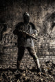 Post-apocalyptic soldier with handmade gun and body armor in an abandoned bunker poster print by Oleg Zabielin.