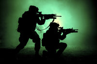 Silhouette of two soldiers attacking in battle surrounded by fire and smoke.