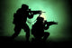Silhouette of two soldiers attacking in battle surrounded by fire and smoke.
