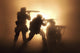 Silhouette of three soldiers attacking in combat surrounded by fire and smoke poster print.