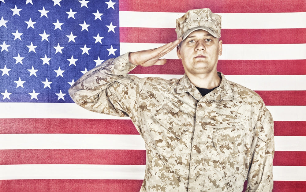 U.S. soldier in camouflage uniform saluting American flag poster print.