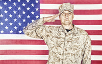 U.S. soldier in camouflage uniform saluting American flag poster print.