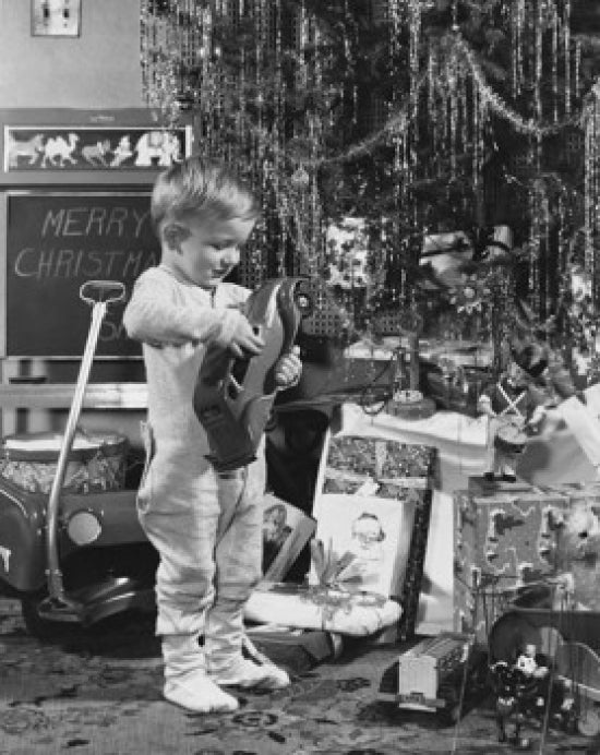 Boy playing with toys near a beautifully decorated Christmas tree poster print.
